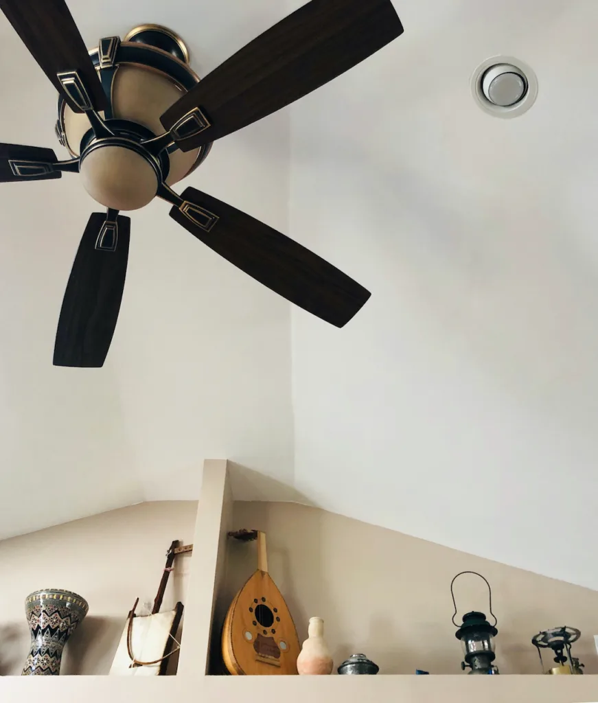 Vaulted ceiling with a ceiling fan and a shelf for display