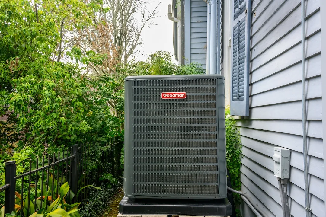 New Goodman air conditioning unit on side of historic home